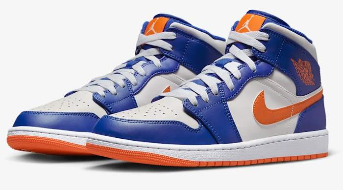 View of white, blue, and orange Air Jordan shoes.